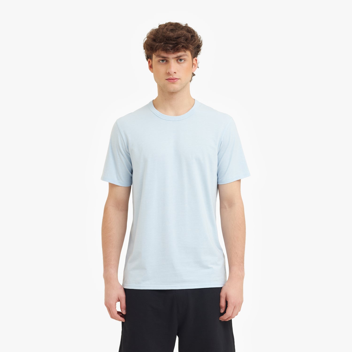Person wearing a light blue t-shirt on a white background