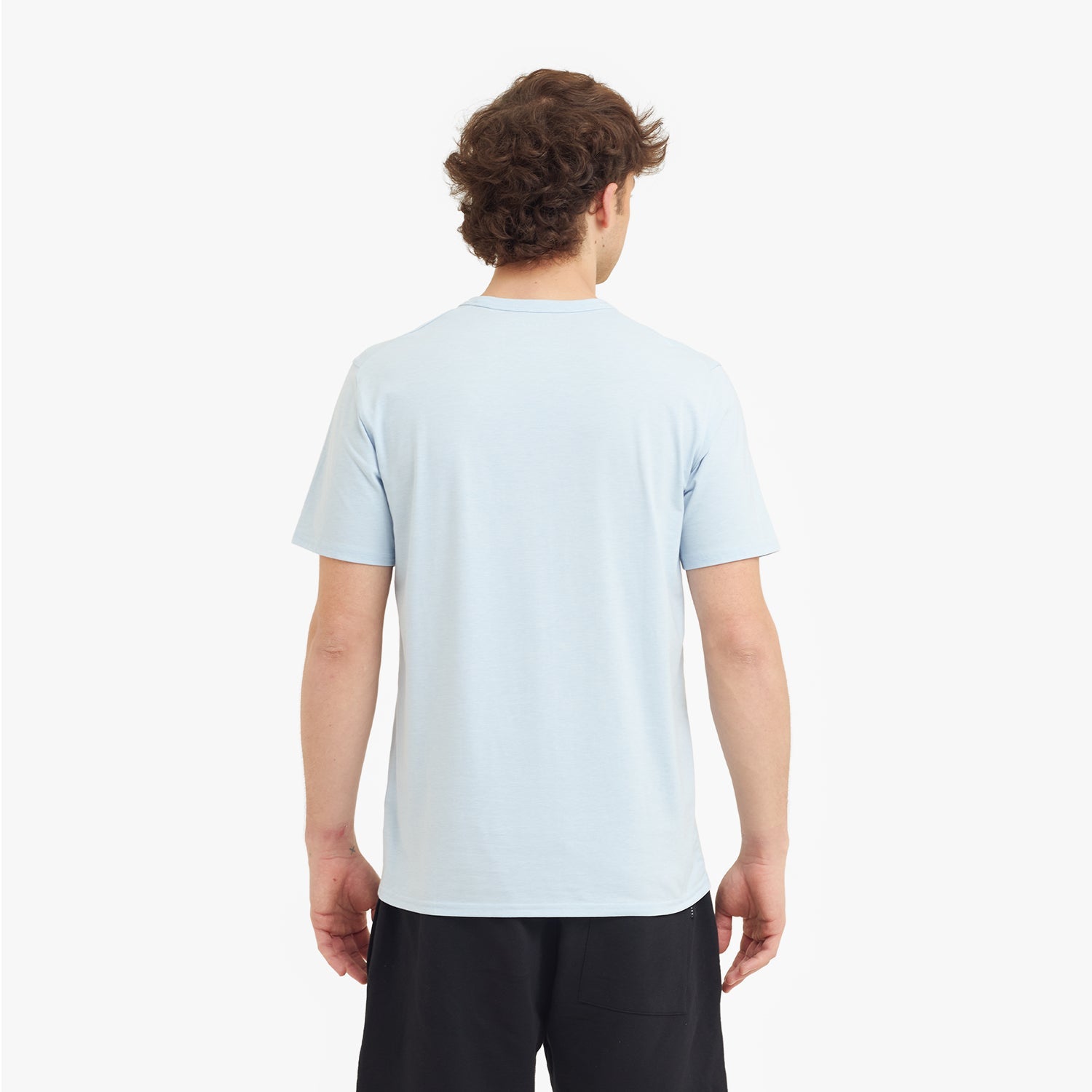 Person wearing a light blue t-shirt on a white background