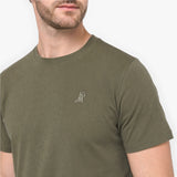 Man wearing a green t-shirt with a small logo on a white background
