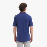 Back view of a man wearing a blue polo shirt on a white background