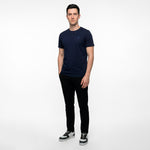 Man wearing a navy blue t-shirt and black pants on a white background