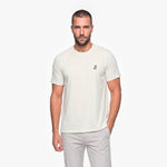 Man wearing a white t-shirt with a small logo on a white background