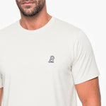Man wearing a white t-shirt with a small logo on the chest against a white background