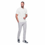 Man wearing a white polo shirt and gray pants on a white background