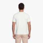 Man wearing a plain white t-shirt and beige pants on a white background