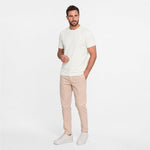 Man wearing a white t-shirt and beige pants on a white background