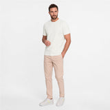 Man wearing a white t-shirt and beige pants on a white background