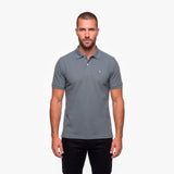 Man wearing a gray polo with a white embroidered logo on a white background