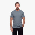 Man wearing a gray t-shirt with a small logo on a white background