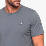 Gray t-shirt with a small logo on the chest worn by a person