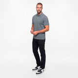 Man wearing a gray polo shirt and black pants on a white background