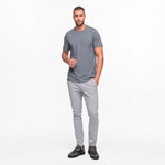 Man wearing a gray t-shirt and pants on a white background