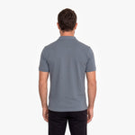 Back view of a man wearing a gray polo