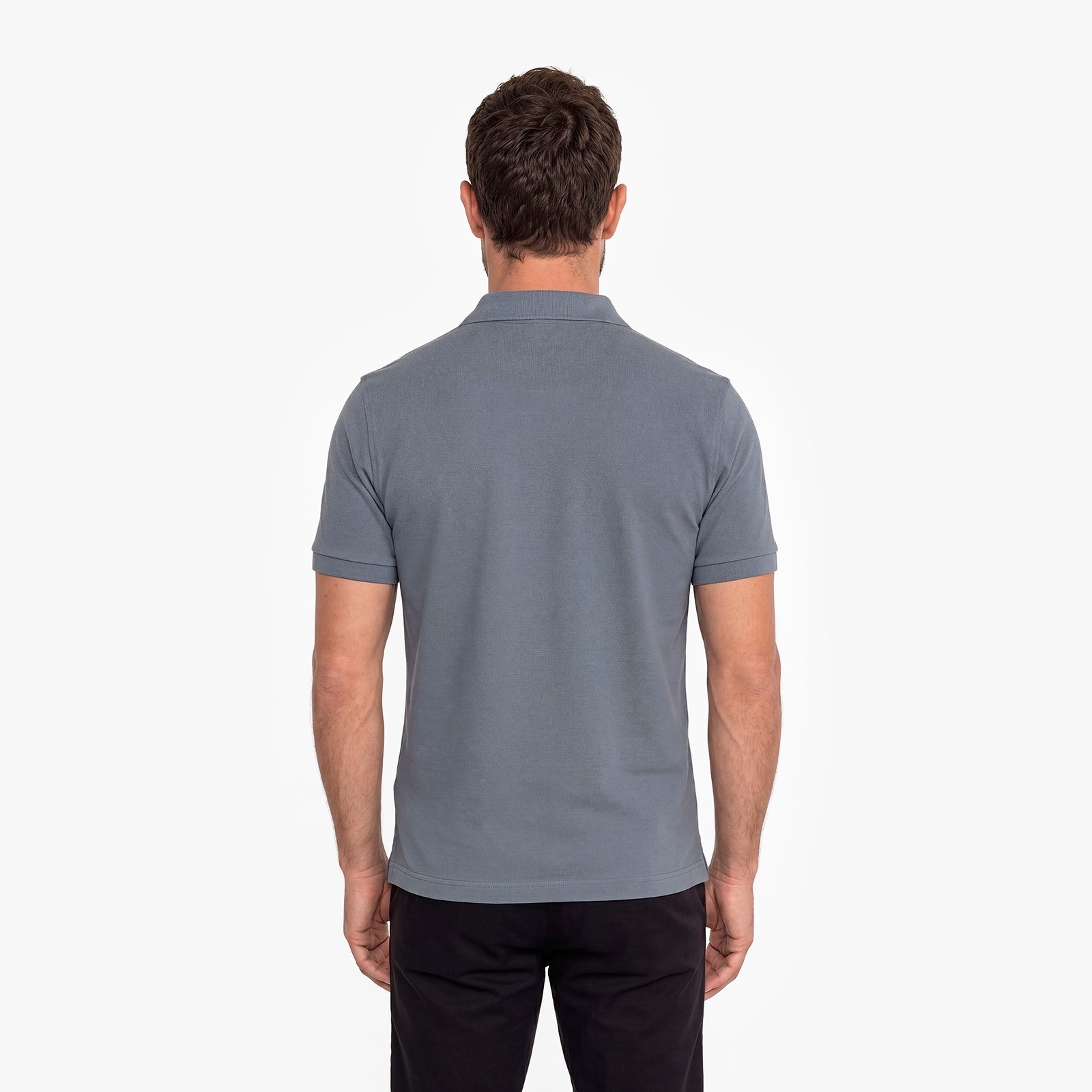 Back view of a man wearing a gray polo
