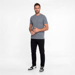 Man wearing a gray t-shirt and black pants on a white background