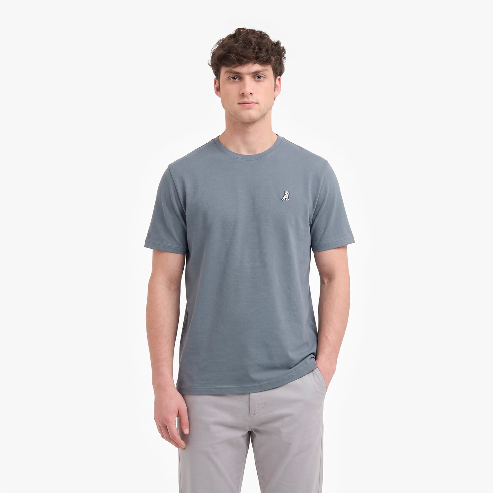 A man wearing a slate gray short-sleeve crewneck t-shirt with a small white embroidered logo