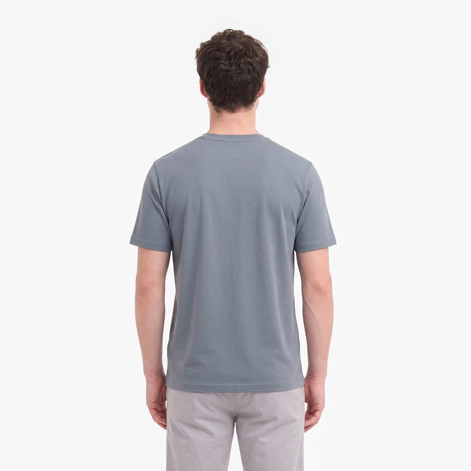 A man viewed from behind wearing a plain gray short-sleeve crewneck t-shirt