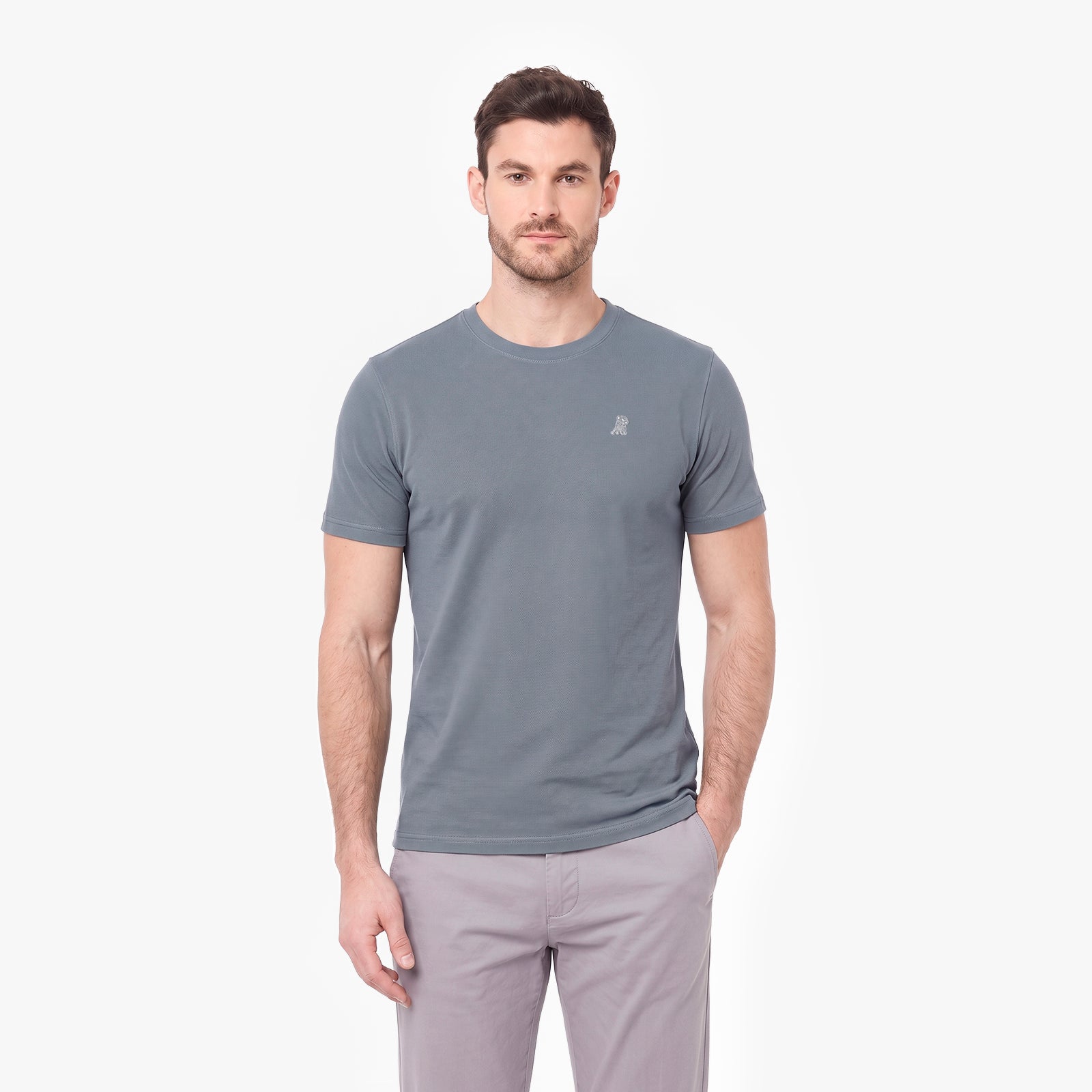A man wearing a gray short-sleeve crewneck t-shirt with a small white embroidered logo