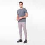 A man modeling a dark gray crew-neck t-shirt and light gray trousers against a plain white background.