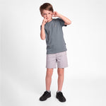 A young boy modeling a short-sleeve crewneck t-shirt in slate gray and light gray shorts, paired with black sneakers