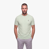 Man wearing a light green t-shirt with a white logo on a white background
