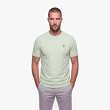 Man wearing a light green t-shirt with a small logo on a white background