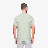 Man wearing a light green polo shirt on a white background