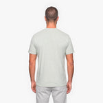 Man wearing a light gray t-shirt and pants on a white background
