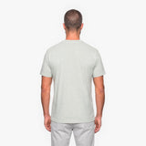 Man wearing a light gray t-shirt and pants on a white background