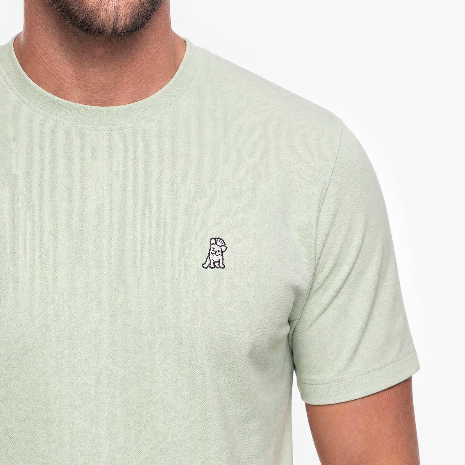 Light green t-shirt with a small logo on a white background