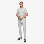 Man wearing a light gray t-shirt and pants on a white background