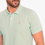 Close-up of a light green polo with a light green embroidered logo