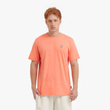 Man wearing a coral t-shirt with a small logo on a white background