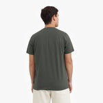 Back view of a man wearing a green t-shirt on a white background