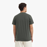 Back view of a man wearing a green t-shirt on a white background