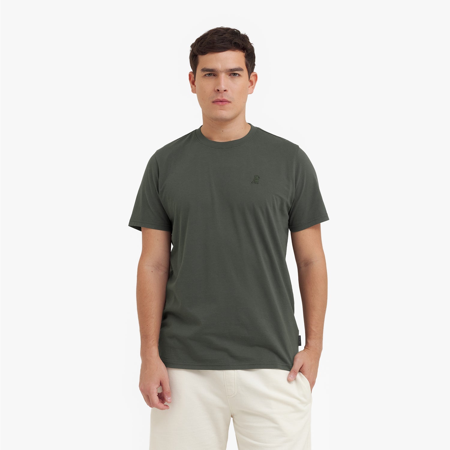 Man wearing a green t-shirt with a small logo on a white background