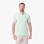 A man wearing a light mint green short-sleeve polo shirt with a small embroidered logo on the left chest