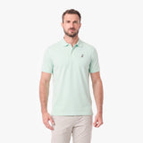 A man wearing a light mint green short-sleeve polo shirt with a small embroidered logo on the left chest
