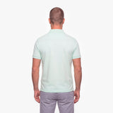 Man wearing a light green polo shirt on a white background