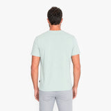 Back view of a man wearing a light green t-shirt on a white background