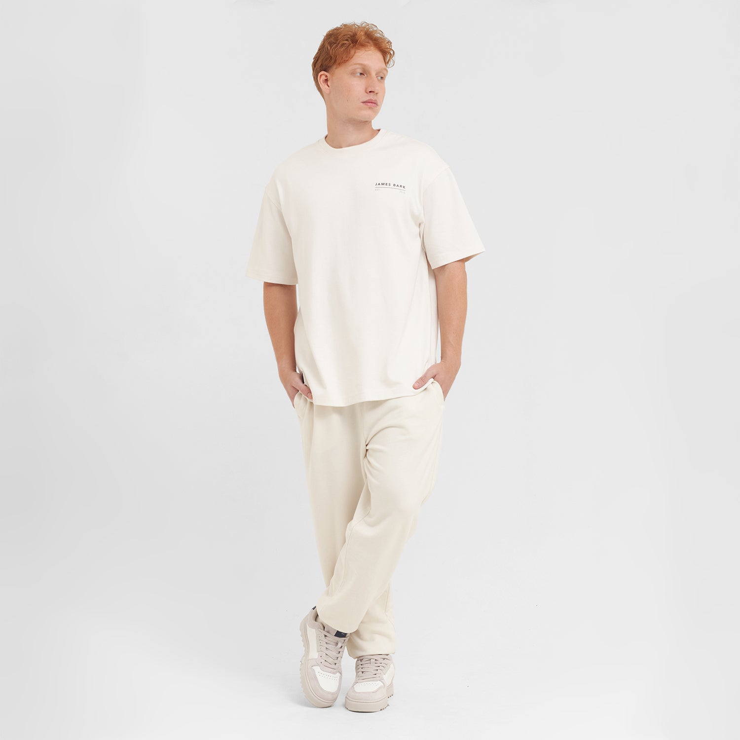 Person wearing a white t-shirt and pants on a white background