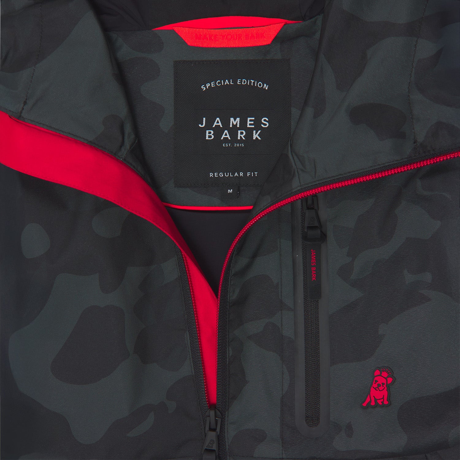 Close-up of the inside of a camouflage-patterned jacket. A black label reads "SPECIAL EDITION JAMES BARK." The lining is bright red.