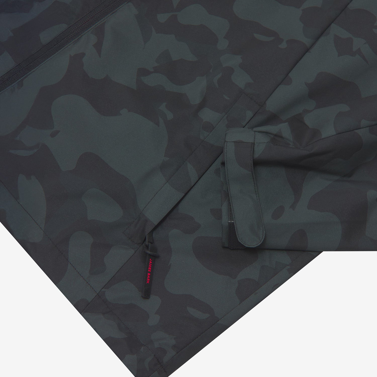 Close-up of the lower pocket and sleeve cuff of a camouflage-patterned jacket. 