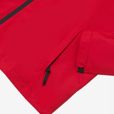 Close-up of the lower pocket and sleeve cuff of a red jacket. 