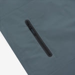 Close-up of the chest pocket of a slate blue jacket.