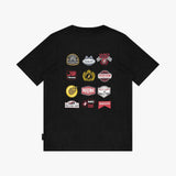 A black short-sleeve t-shirt with a graphic print of twelve racing-themed patches on the front, displayed against a light gray background.