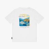 A white short-sleeve crewneck t-shirt featuring a central graphic print of a yacht on blue water with the text 'JAMES Yacht Club BARK' and 'LUXURY BY THE COAST'.