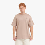 A male model with red hair wearing a beige oversized t-shirt, shown from the chest up.