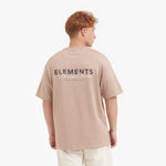 Male model showing the back of the beige t-shirt with the "ELEMENTS Design Studio" graphic