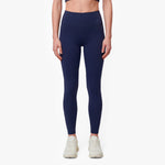 Person wearing navy blue leggings on a white background